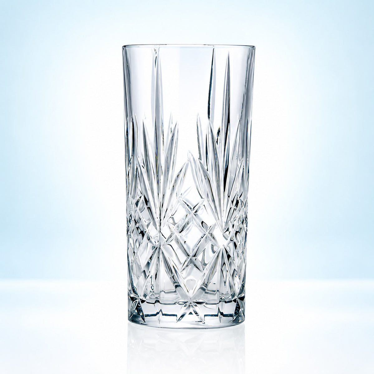 Verre long drink RCR Melodia 36 cl taillé de losanges et d'étoiles, vu de face sur fond bleu clair