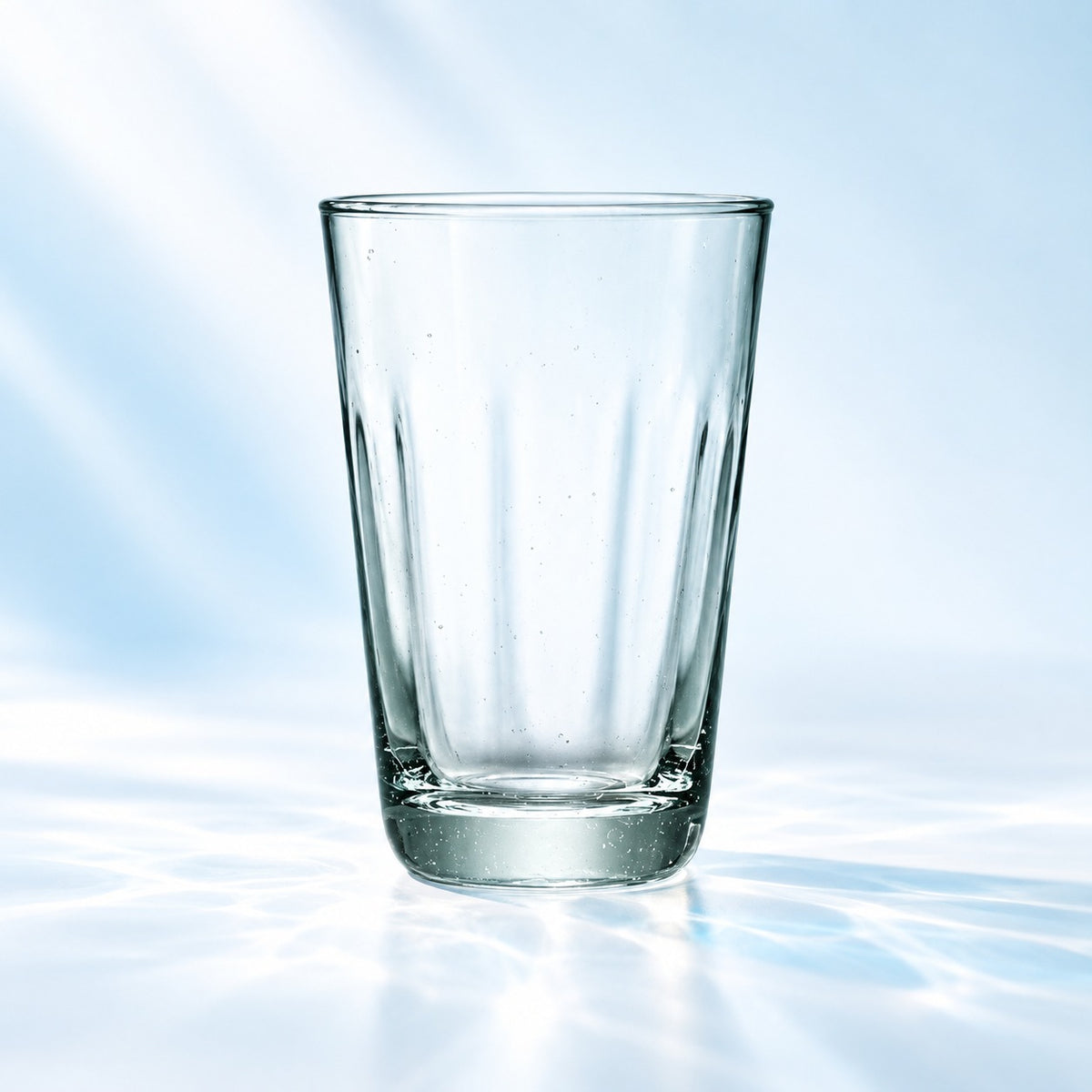 Verre long drink Mia Recycled Glass 35 cl à texture cannelée et teinte légèrement verte, vu de face