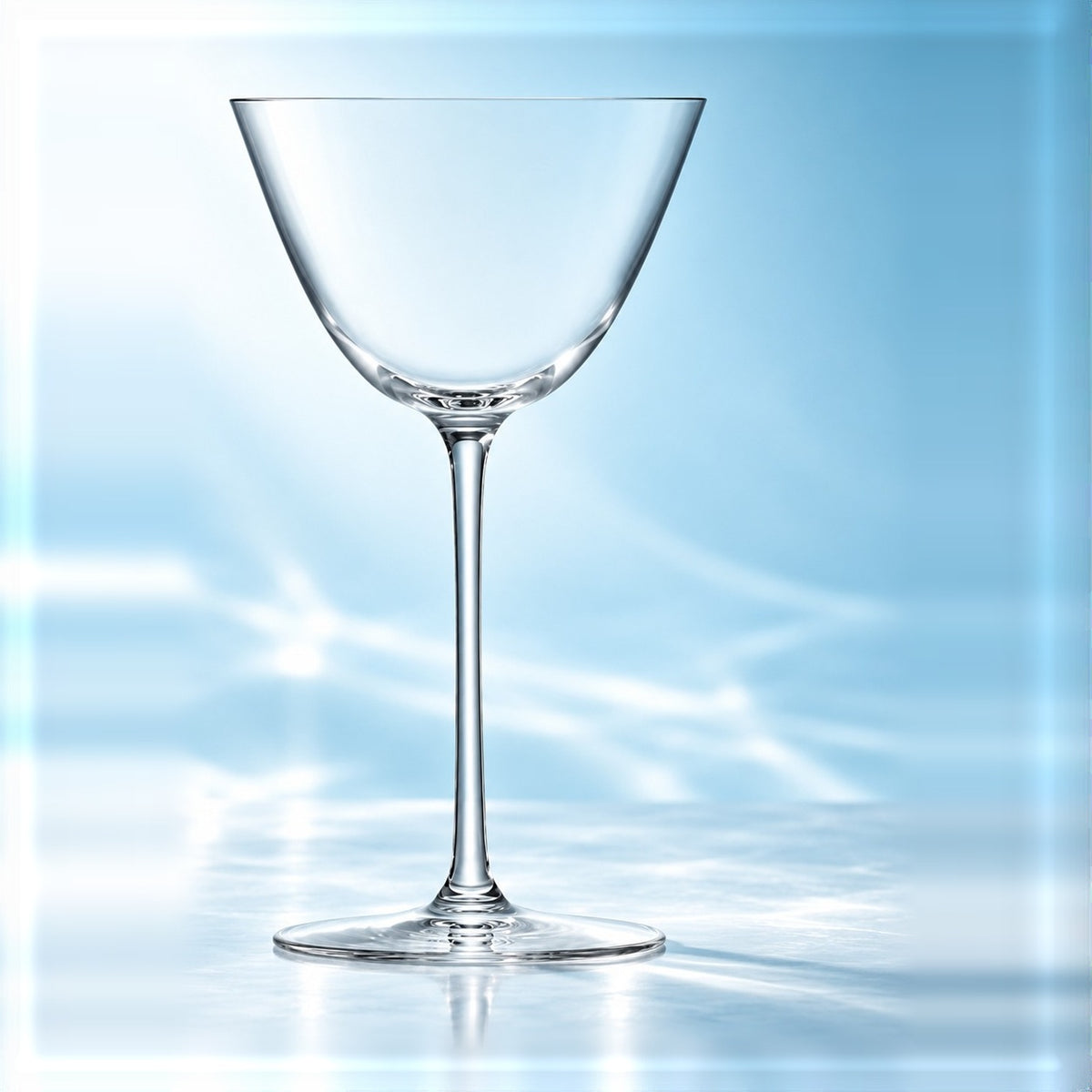 Verre à martini Borough 19 cl à bol conique et pied fin, vu de face sur un plan de marbre lumineux