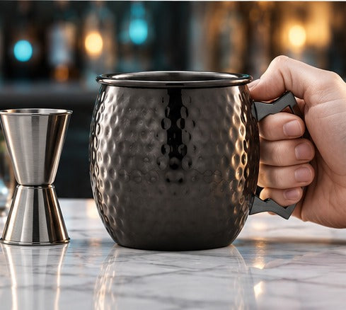 Moscow mule Genware EU Barrel Mug martelé, poignée noire 55 cl, en main, à côté d'un jigger
