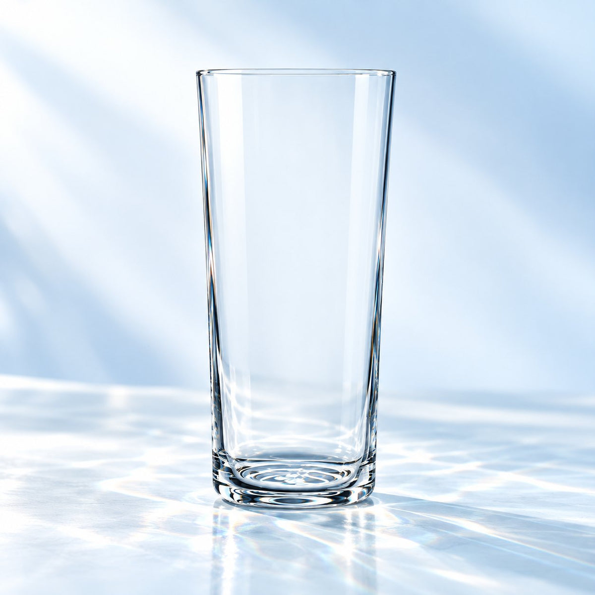 Tumbler High Ball Nude Savage 33 cl, légèrement évasé, vu de face sur un plan de marbre lumineux