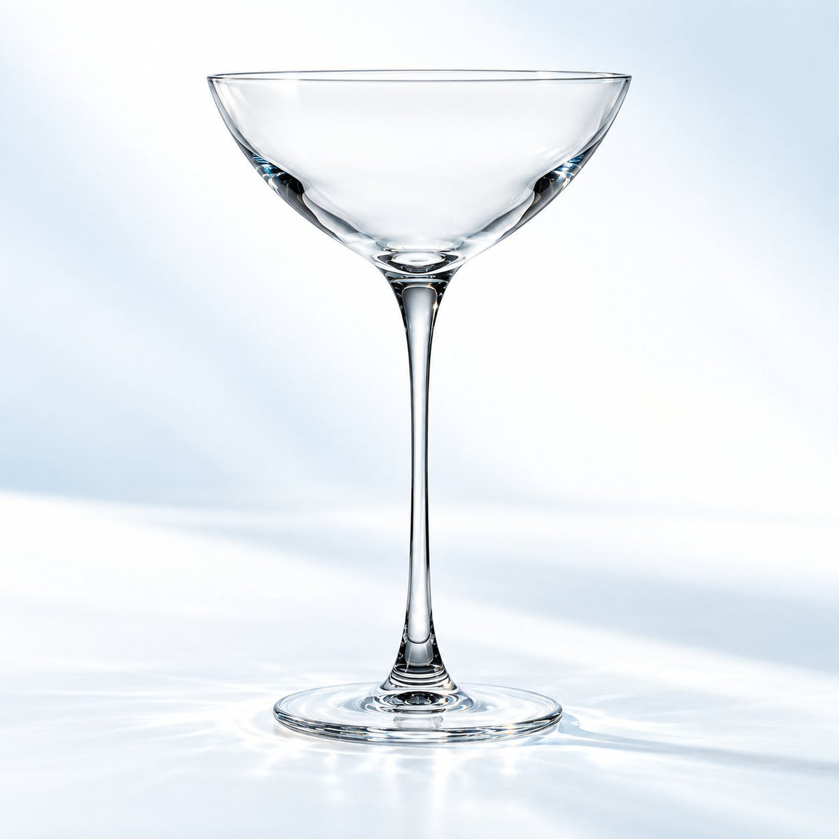Verre Coupetini Nude Savage 17 cl à bol conique et pied fin, vu de face sur un plan de marbre lumineux