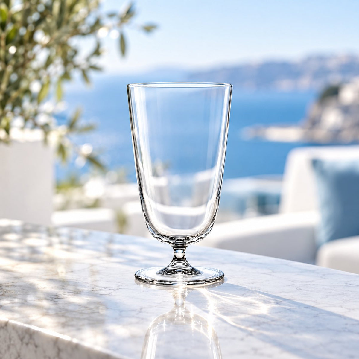 Verre à cocktail long Nude Bar Giani vide sur une terrasse en marbre, vue sur la mer