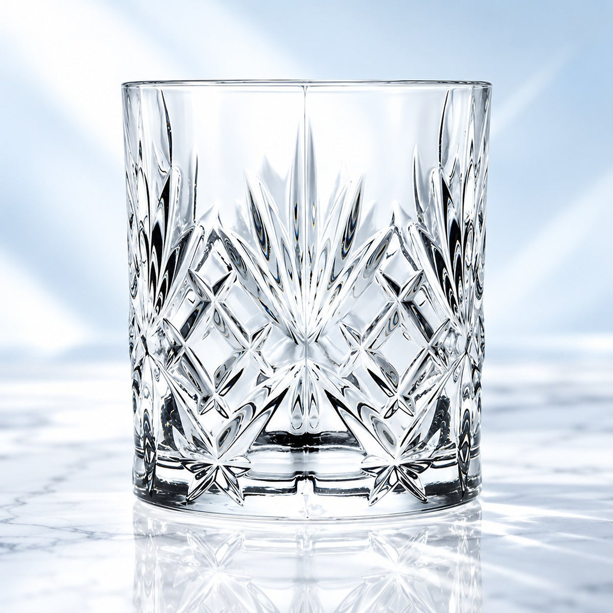 Verre short drink RCR Melodia 31 cl taillé de losanges et d'étoiles, vu de face sur fond bleu clair