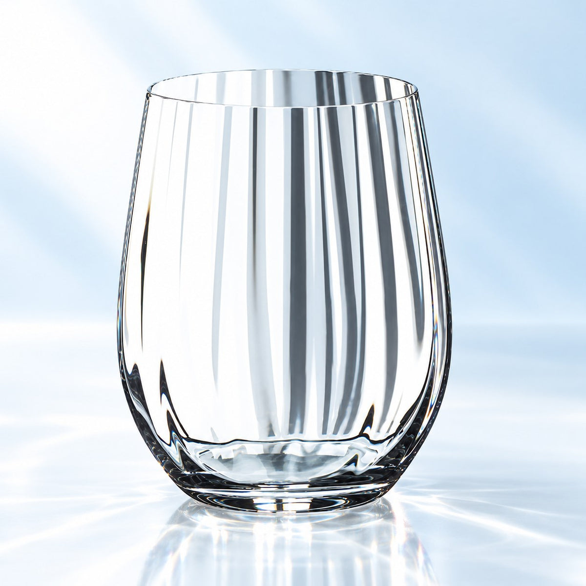 Verre short drink Riedel O optic whisky 34 cl sans pied, à côtes optiques, vu de face sur fond bleu clair