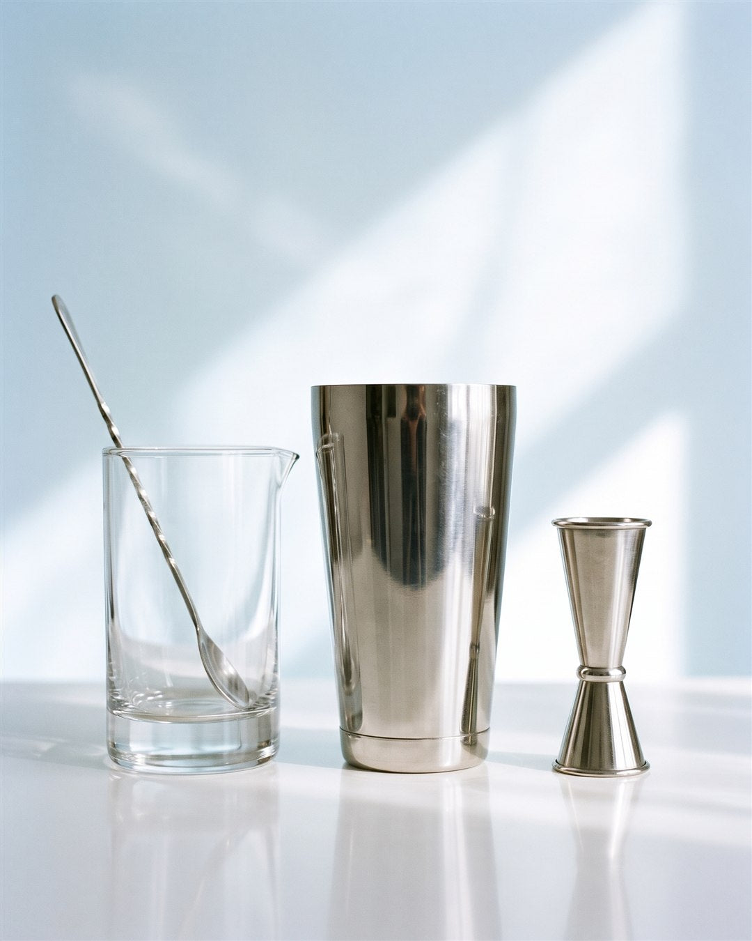 Tin de Boston shaker à côté d'un verre à mélange et d'un jigger inox pour situer sa taille