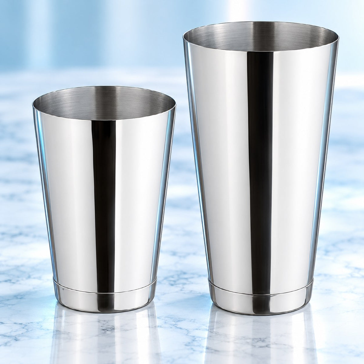 Les deux tins du shaker Boston Classique Lesté en inox miroir, côte à côte sur un plan de marbre clair