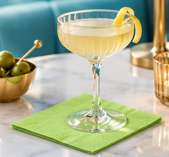 Serviettes en ouate pistache CGMP 20 × 20 cm, pack de 100, servant de sous-verre à un cocktail