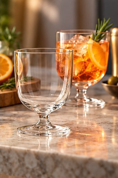 Deux verres Libbey Levitas Rocks avec un cocktail à l'orange sur un comptoir en marbre