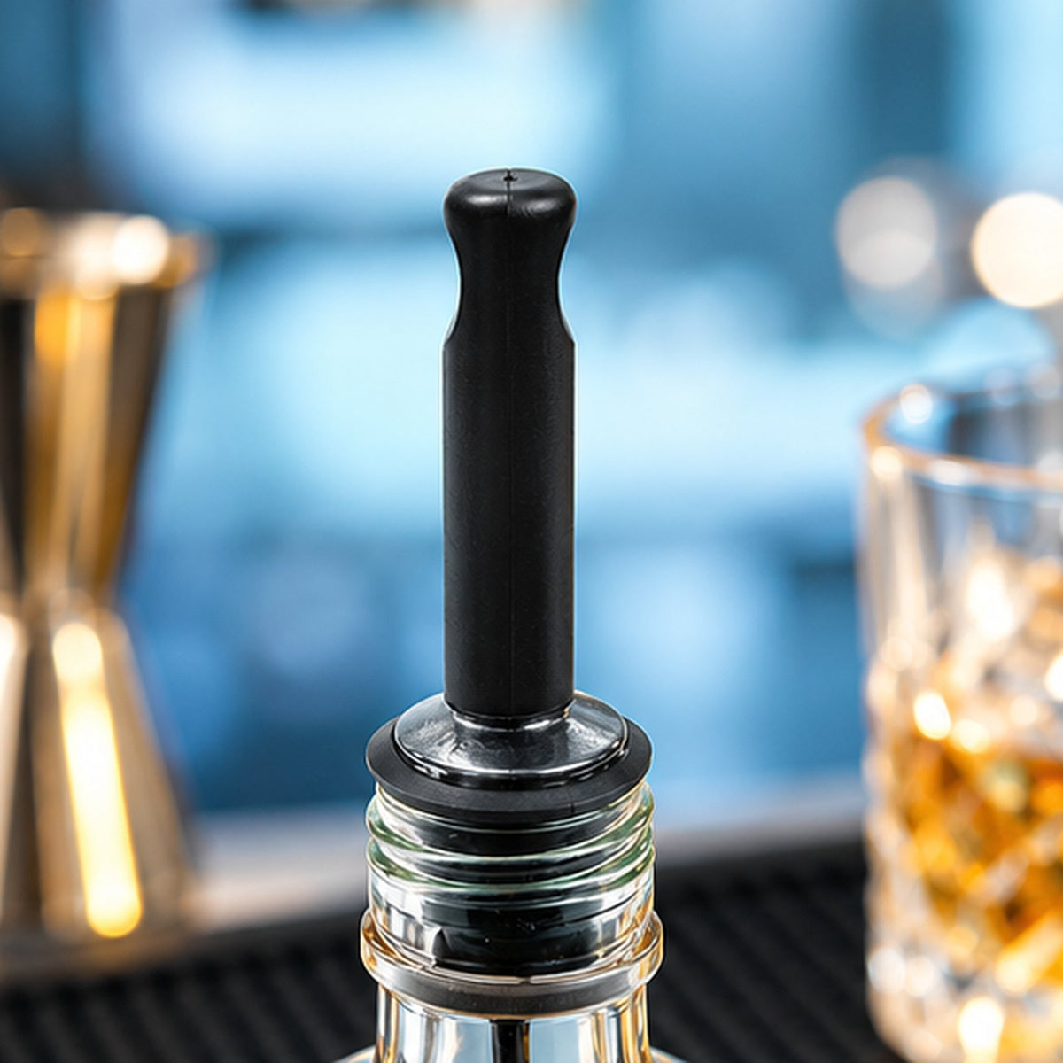 Capuchon bec verseur Beaumont noir, lot de 12, posé sur une bouteille de bar