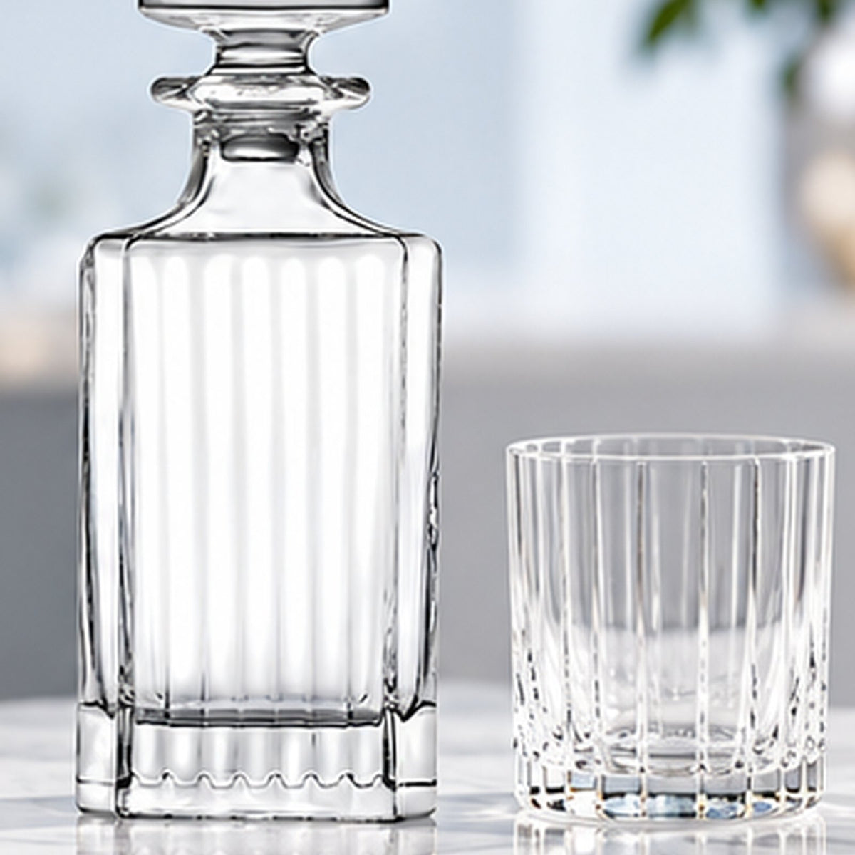 Carafe RCR Timeless posée à côté d'un verre à côtes sur un plan clair
