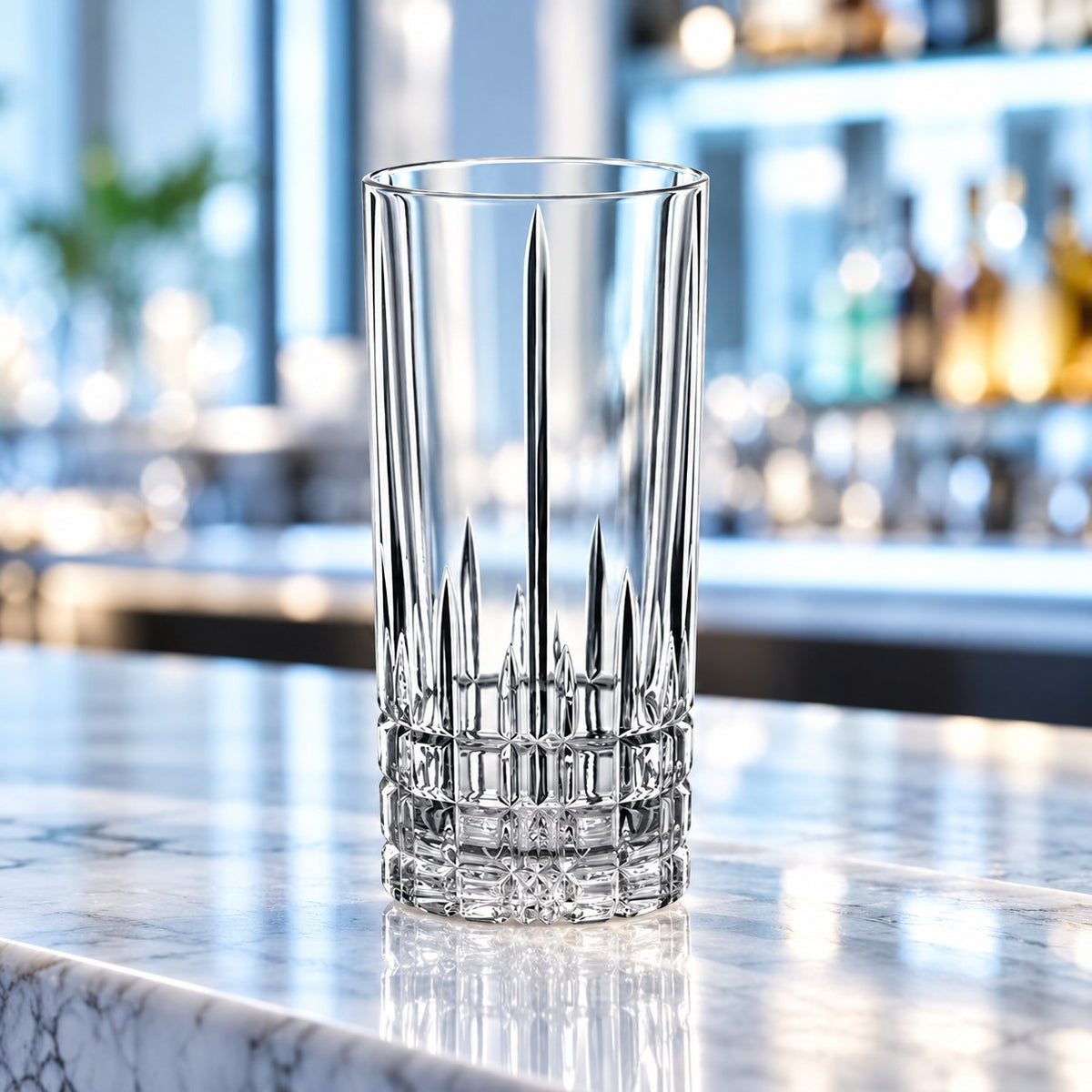 Verre long drink Spiegelau Perfect Serve vide sur un comptoir en marbre devant des bouteilles de bar