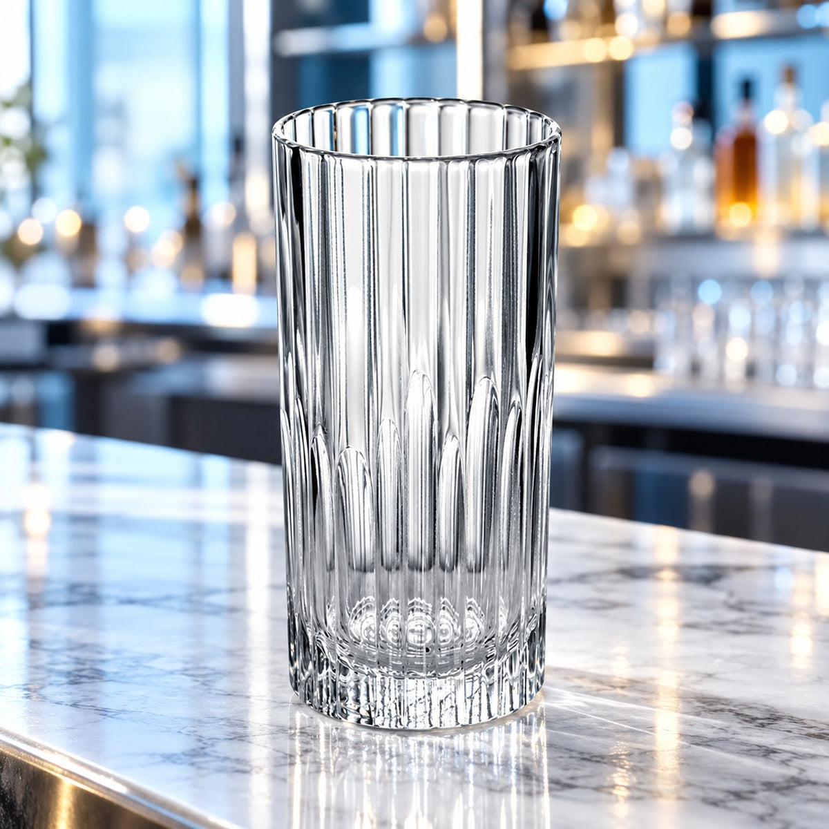Verre long drink Duralex Manhattan vide sur un plan de marbre devant un bar