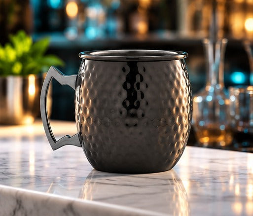Moscow mule Genware EU Barrel Mug martelé, poignée noire 55 cl, près d'une carafe et d'un jigger sur un comptoir de bar