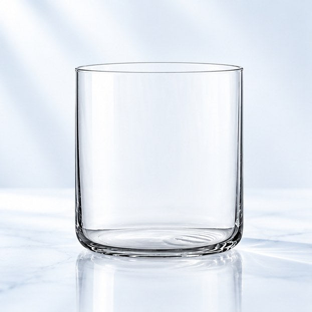 Verre à whisky Nude Finesse 30 cl, forme basse et droite, vu de face sur un plan de marbre lumineux
