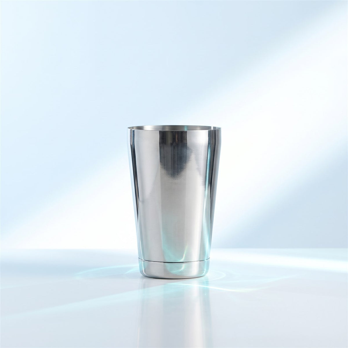Petite tin de Boston shaker en inox poli de 57 cl, debout sur une surface blanche brillante