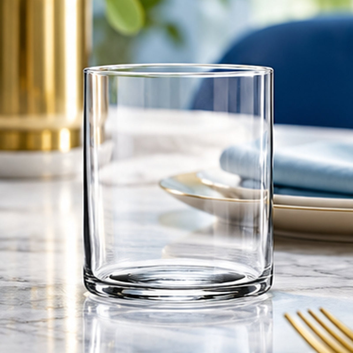 Verre Top Class vide sur une table dressée en marbre avec fourchette dorée et assiette