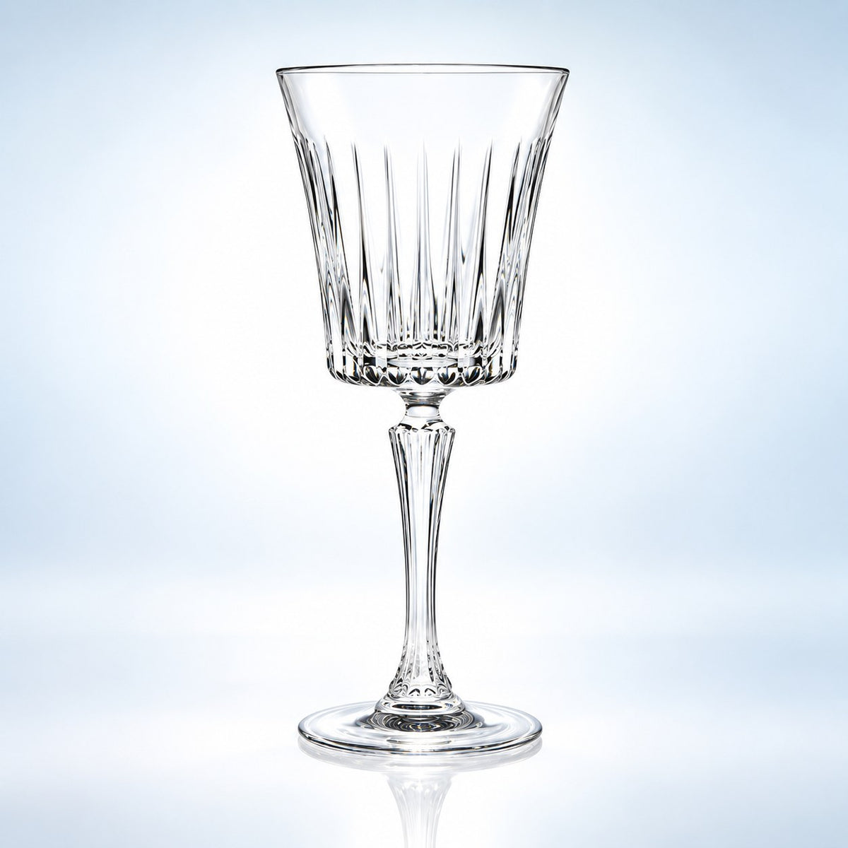 Verre à cocktail RCR Timeless 23 cl à pied et corps évasé taillé de côtes, vu de face sur fond bleu clair