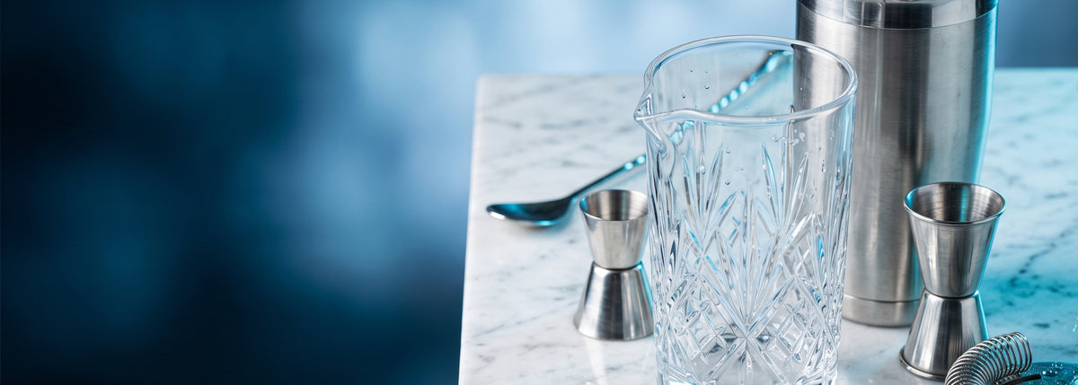 BWA, matériel de bar de qualité professionnelle : shaker Boston en inox et verre à mélange en cristal taillé sur un plan de marbre, avec jiggers